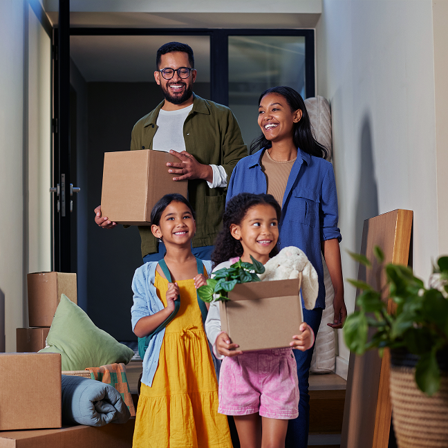 Family carrying moving boxes into their new home.